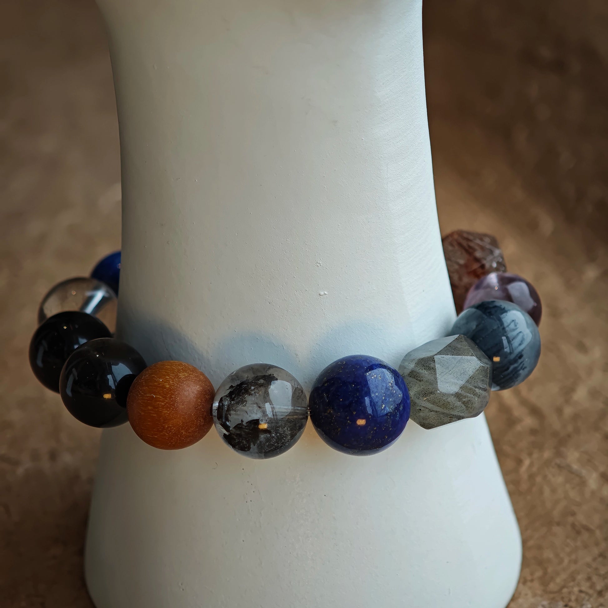 This blue-grey mystery strand blends Black Gold Super Seven, Herkimer diamonds, clear quartz, sandalwood, amethyst, silver obsidian, white phantom quartz, and kyanite.