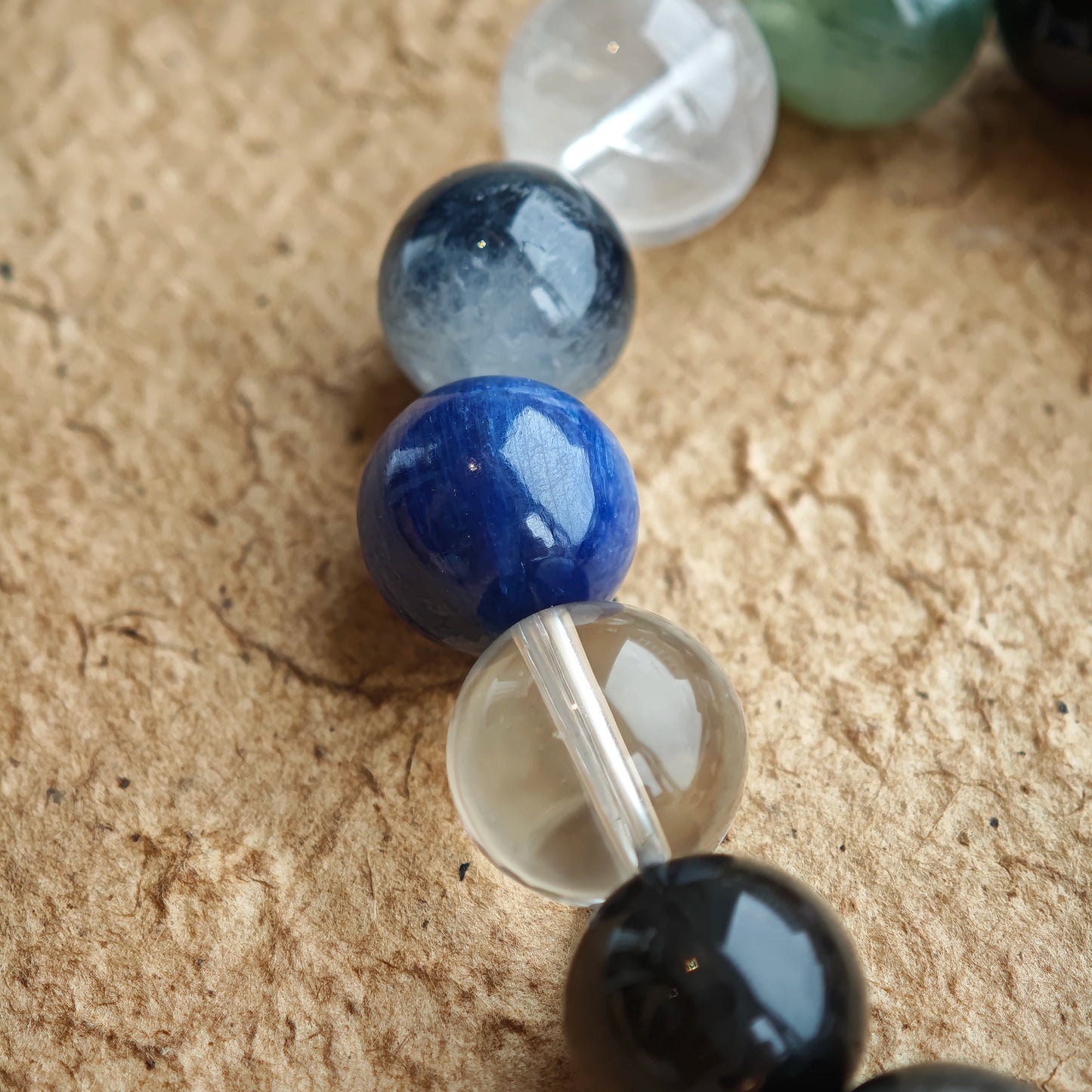 This crystal circle pairs Black Gold Super Seven with Herkimer sparkles, clear quartz clarity, sandalwood warmth, amethyst dusk, silver obsidian shields, white phantom veils, and kyanite skies—an enigmatic blue-grey palette.