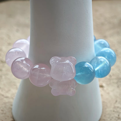 This bracelet consists of rose quartz and aquamarine. The bracelet features a bead pendant and a rhombic spacer, both of which are made of rose quartz. The bracelet is a combination of pink and blue colors.
