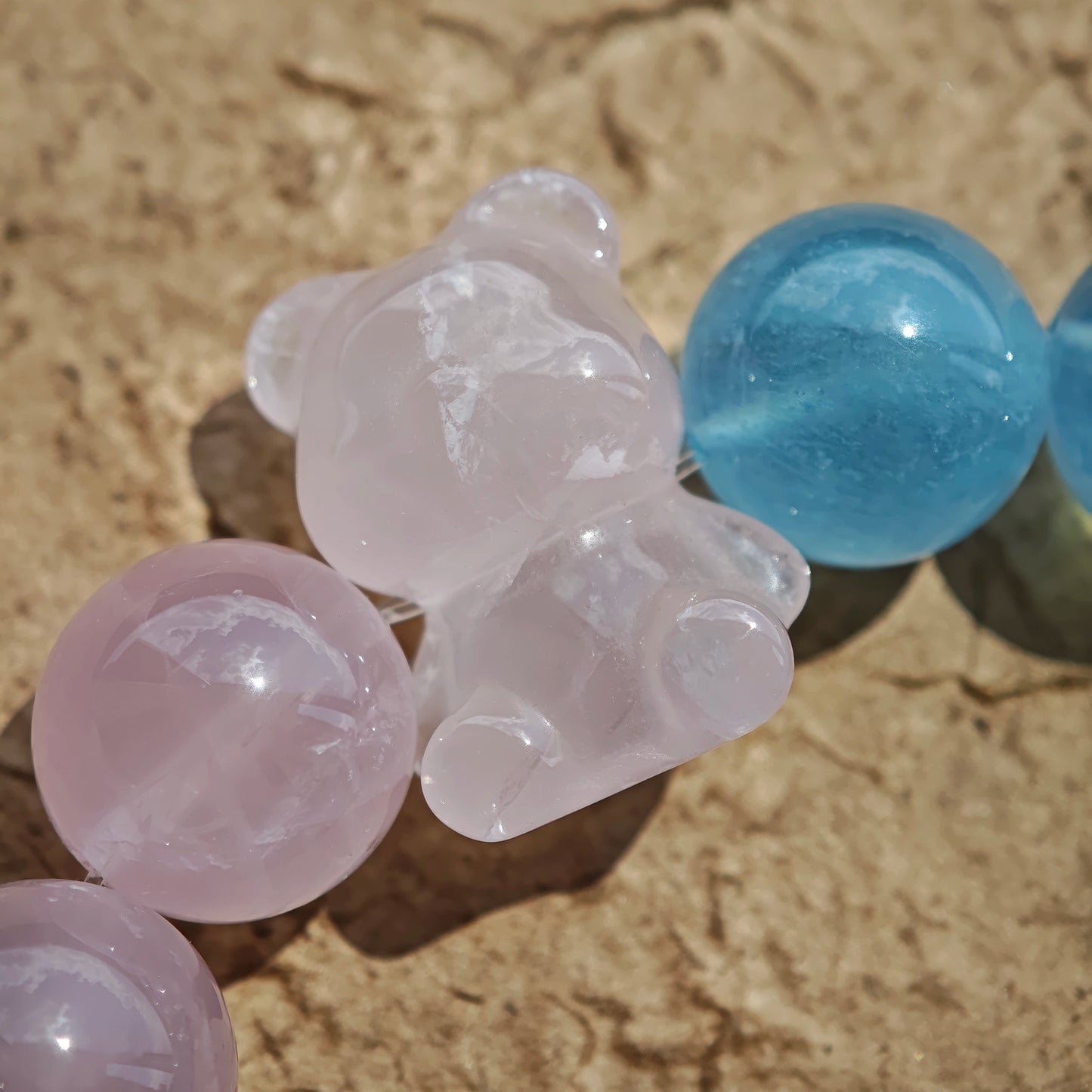 This bracelet consists of rose quartz and aquamarine. The bracelet features a bead pendant and a rhombic spacer, both of which are made of rose quartz. The bracelet is a combination of pink and blue colors.
