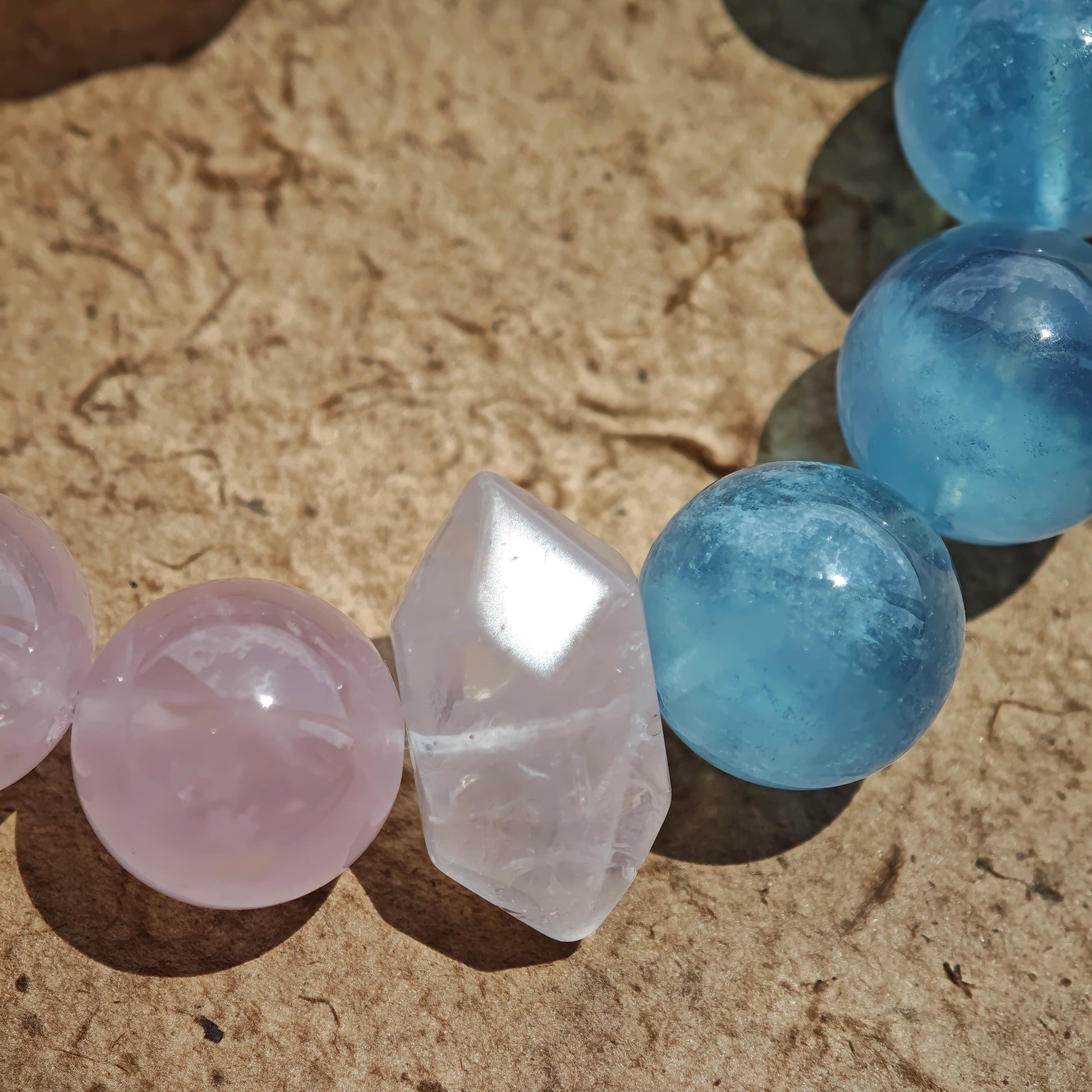 This bracelet consists of rose quartz and aquamarine. The bracelet features a bead pendant and a rhombic spacer, both of which are made of rose quartz. The bracelet is a combination of pink and blue colors.