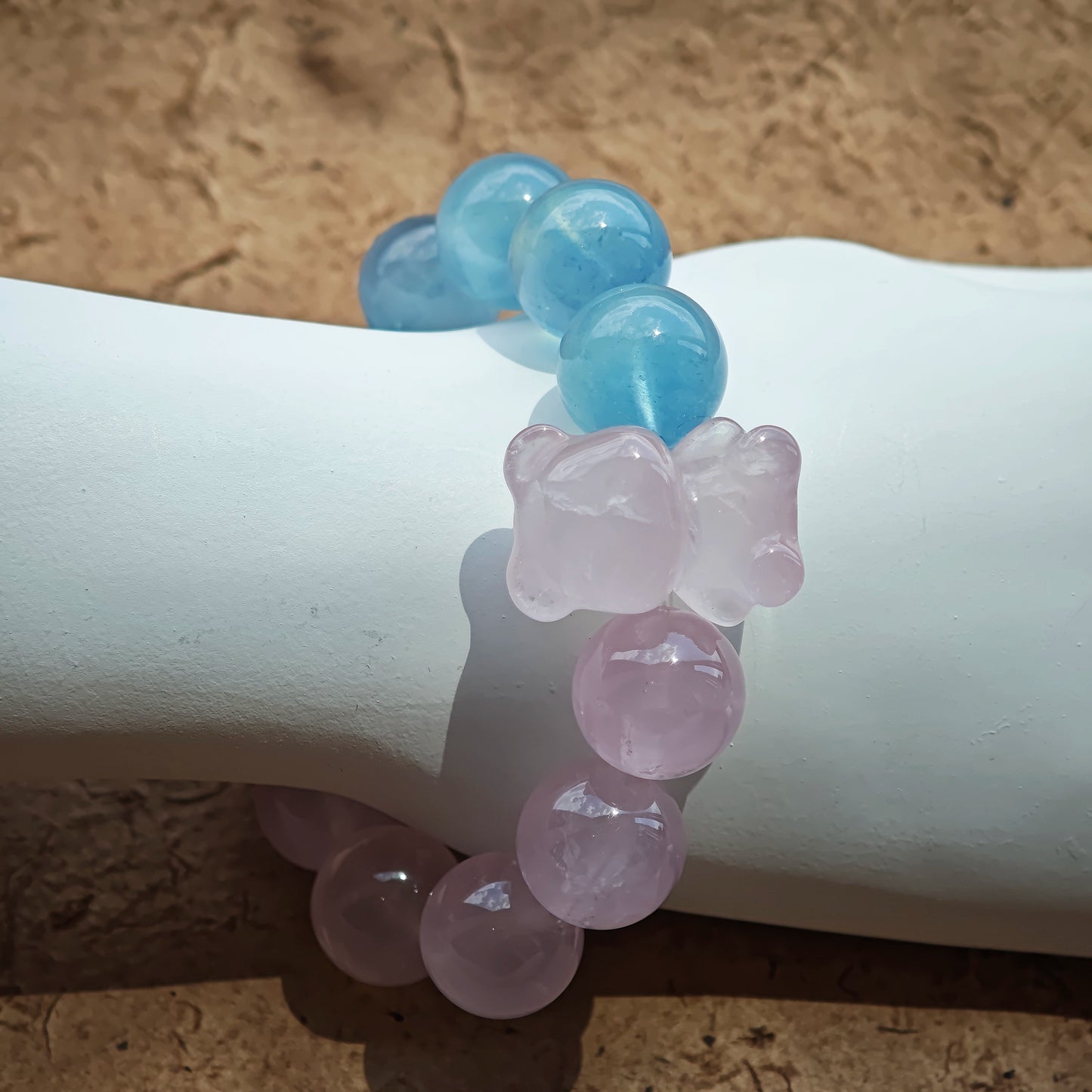This bracelet consists of rose quartz and aquamarine. The bracelet features a bead pendant and a rhombic spacer, both of which are made of rose quartz. The bracelet is a combination of pink and blue colors.