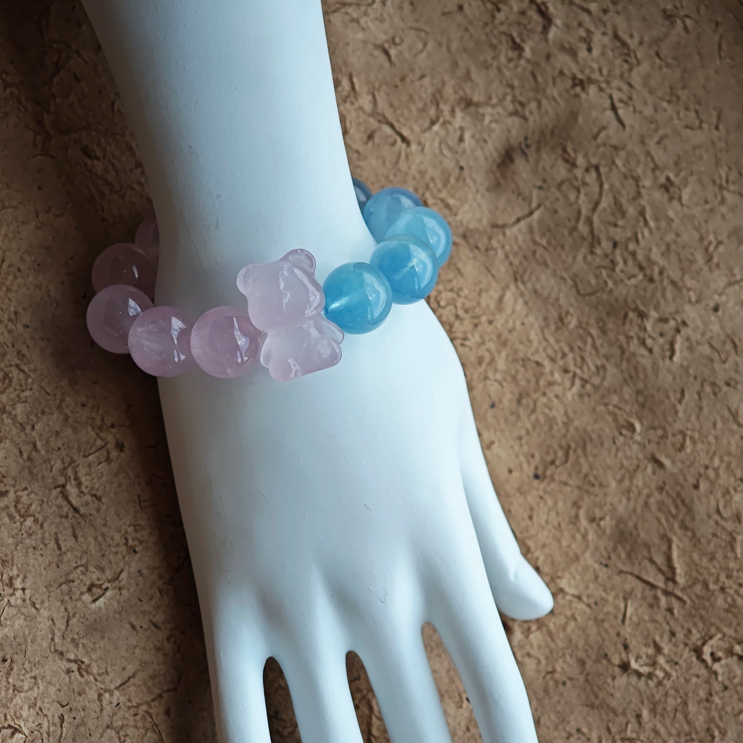 This bracelet consists of rose quartz and aquamarine. The bracelet features a bead pendant and a rhombic spacer, both of which are made of rose quartz. The bracelet is a combination of pink and blue colors.