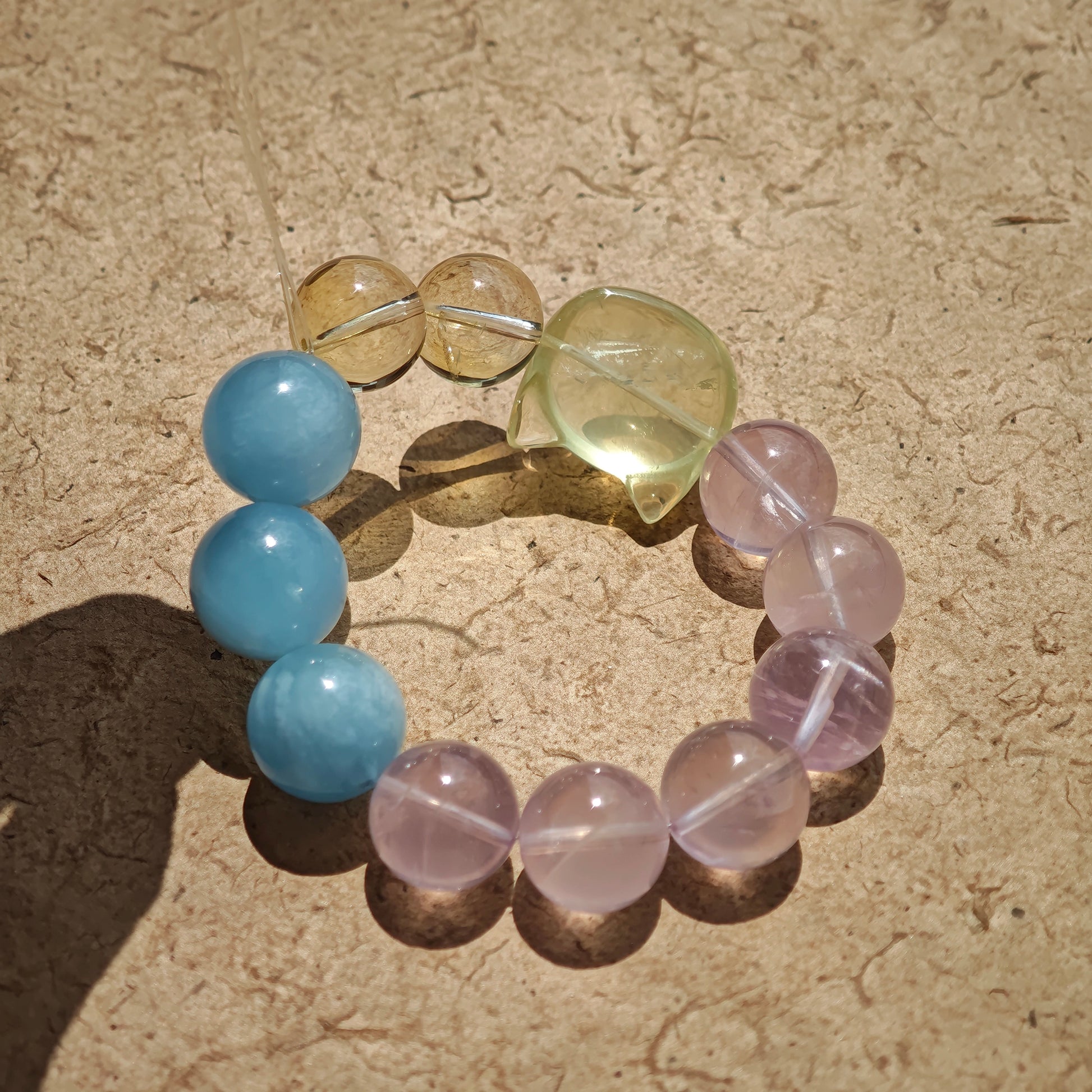 This is a Rose Quartz Bracelet with Aquamarine, Citrine crystal and cat charm.