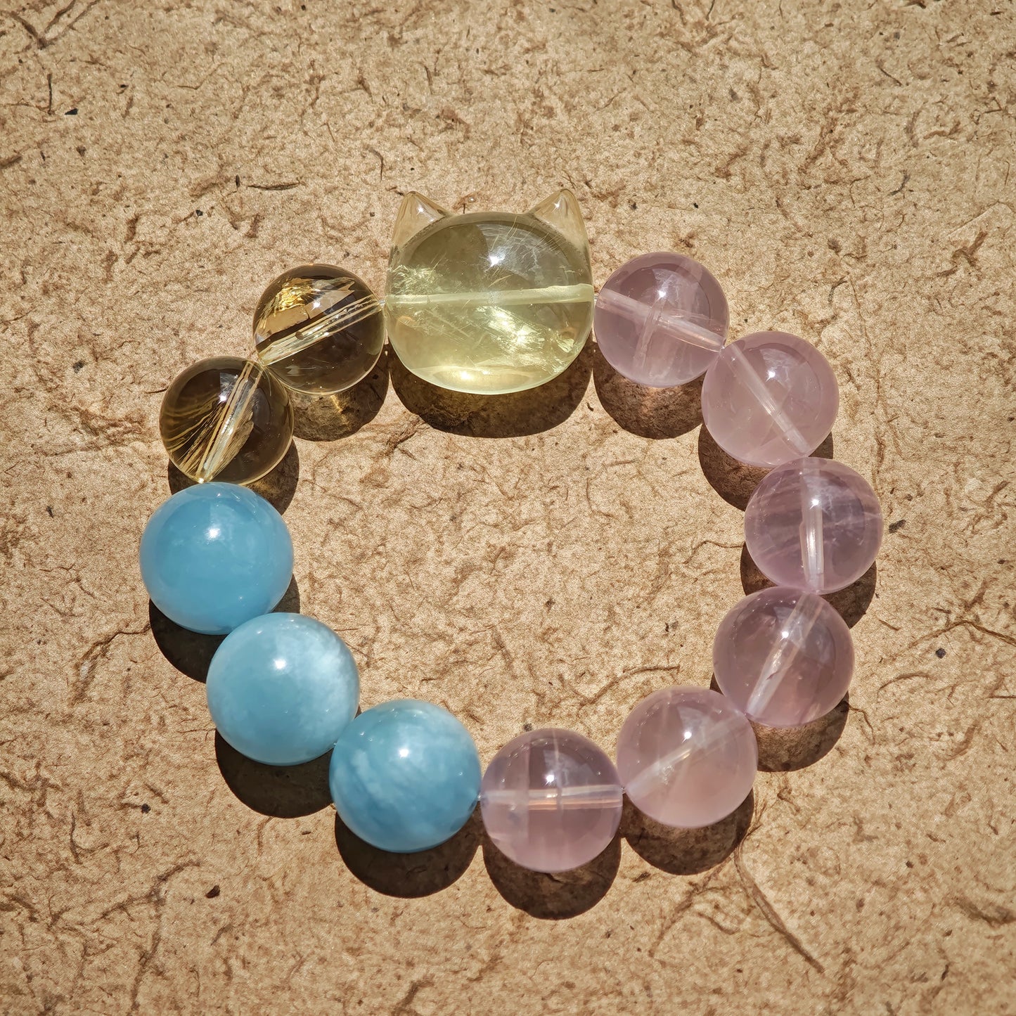 This is a Rose Quartz Bracelet with Aquamarine, Citrine crystal and cat charm.