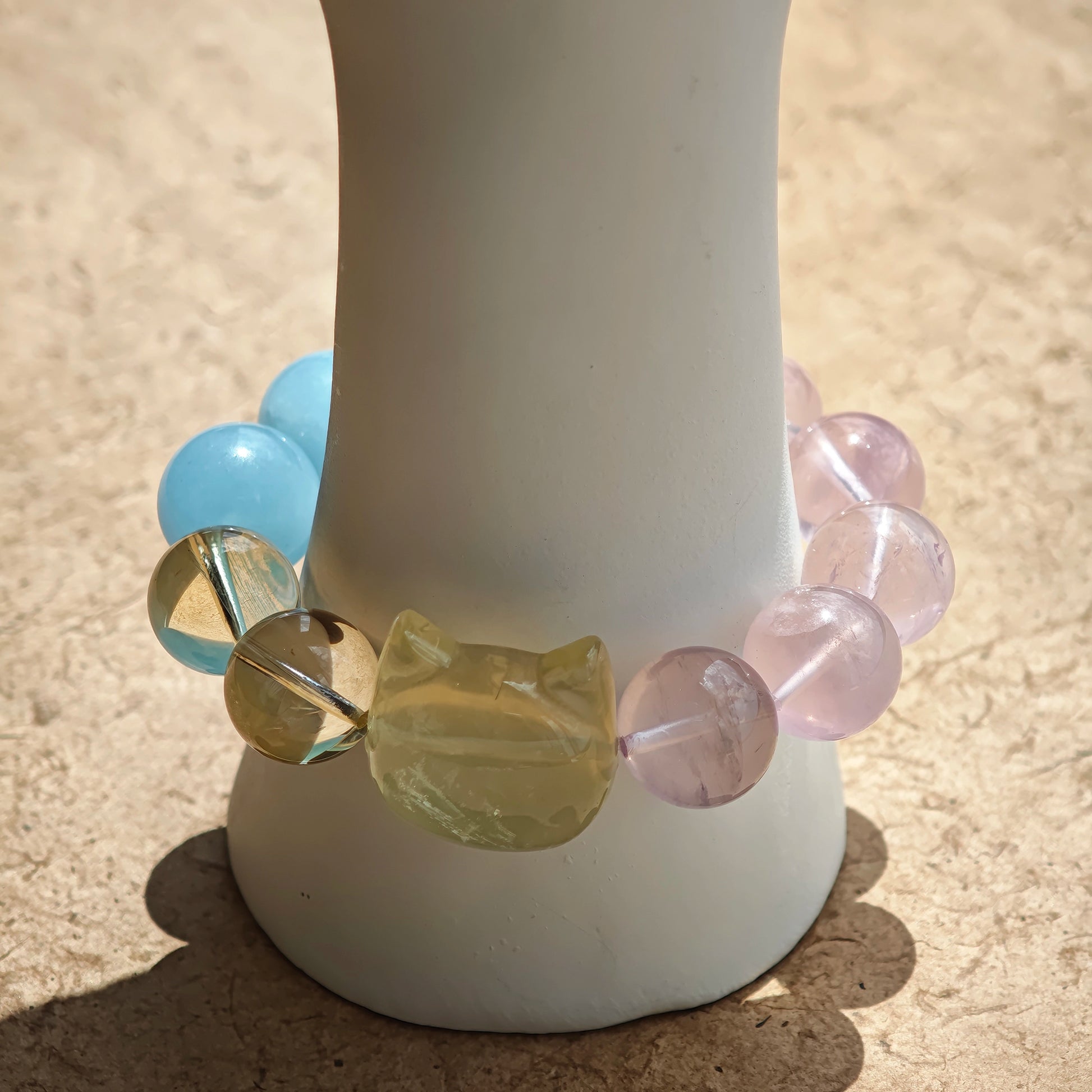 This is a Rose Quartz Bracelet with Aquamarine, Citrine crystal and cat charm.