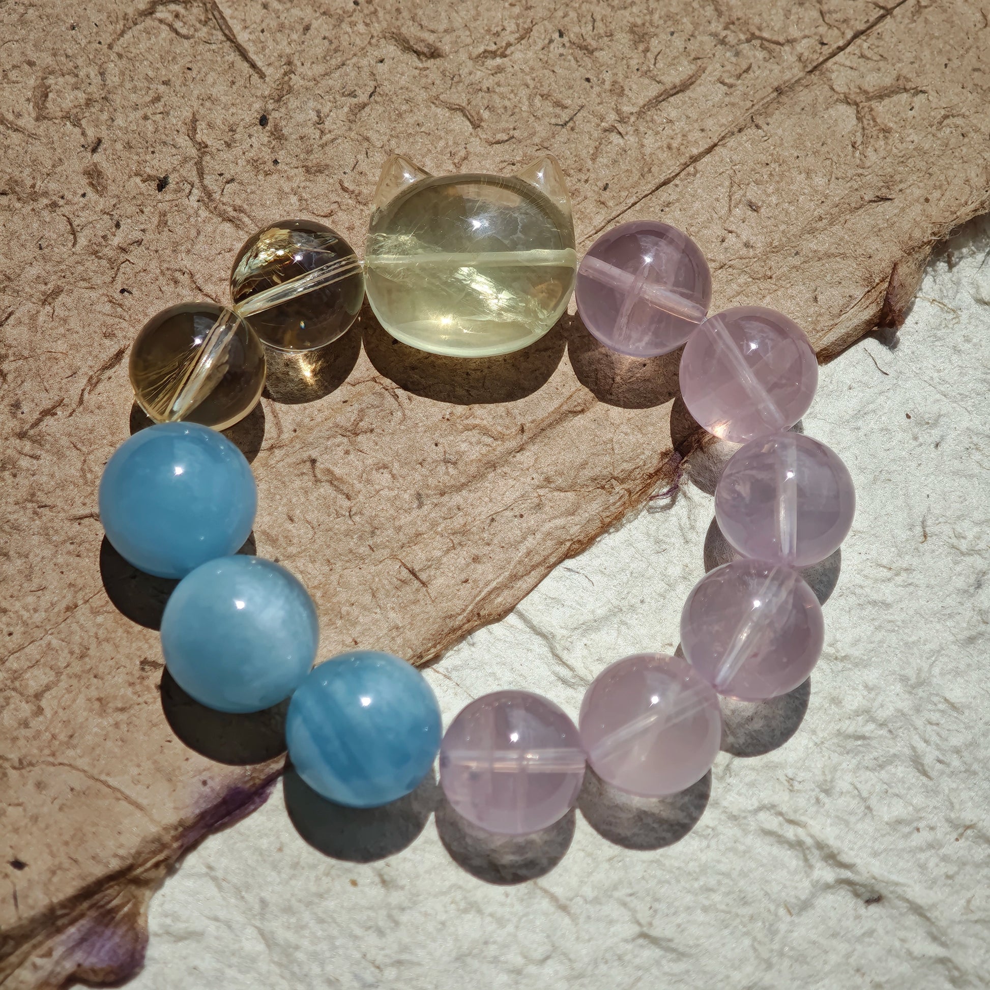 This is a Rose Quartz Bracelet with Aquamarine, Citrine crystal and cat charm.