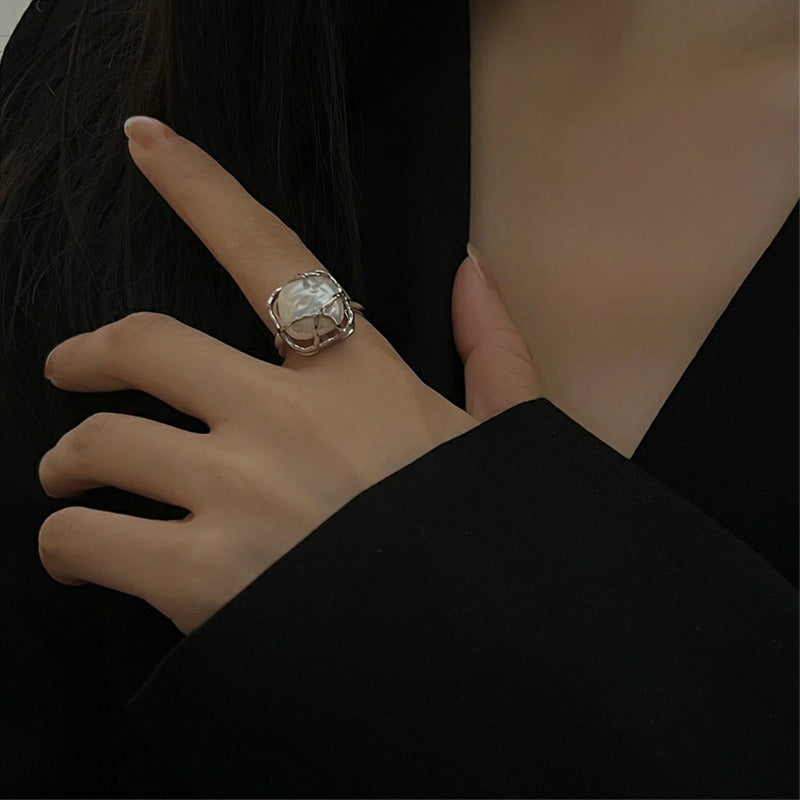 This is a S925 ring with white gold finish. In the ring, there is a square baroque pearl. This is an adjustable ring that carries organic texture and irregular beauty.