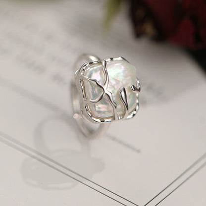 This is a S925 ring with white gold finish. In the ring, there is a square baroque pearl. This is an adjustable ring that carries organic texture and irregular beauty.