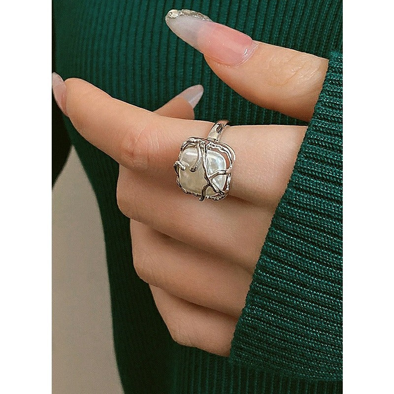 This is a S925 ring with white gold finish. In the ring, there is a square baroque pearl. This is an adjustable ring that carries organic texture and irregular beauty.