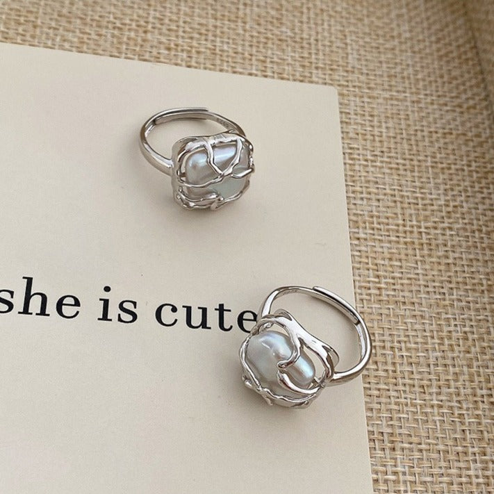 This is a S925 ring with white gold finish. In the ring, there is a square baroque pearl. This is an adjustable ring that carries organic texture and irregular beauty.