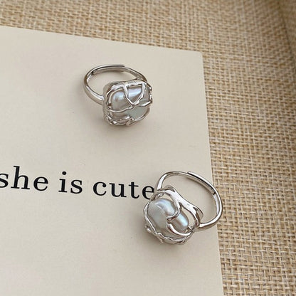 This is a S925 ring with white gold finish. In the ring, there is a square baroque pearl. This is an adjustable ring that carries organic texture and irregular beauty.