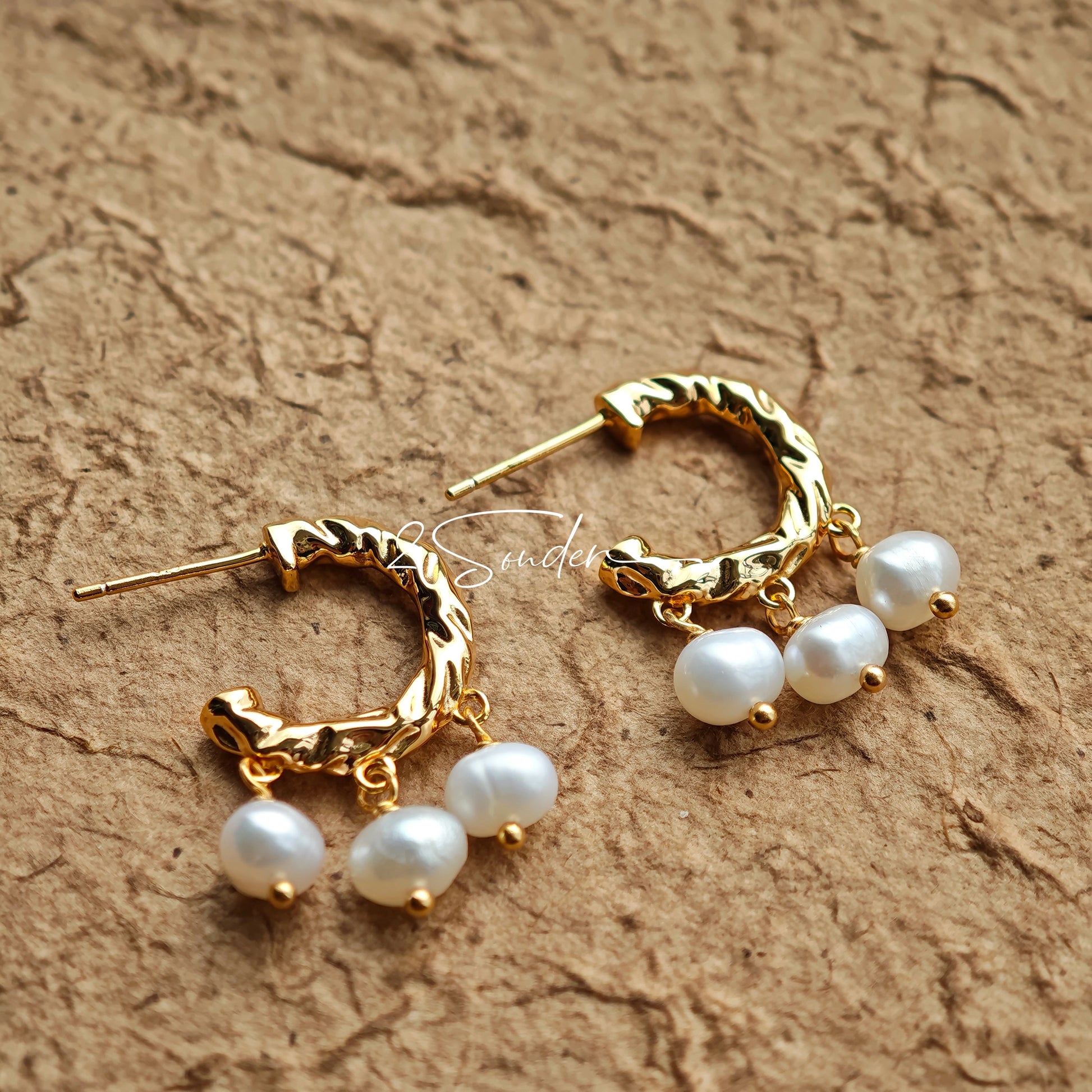 This is a pair of earrings made of sterling silver and natural pearls. The sterling silver is plated with gold, and a crescent-shaped pendant holds three pearls, each approximately 6mm in diameter. The earrings are approximately 2cm in height, a perfect size.