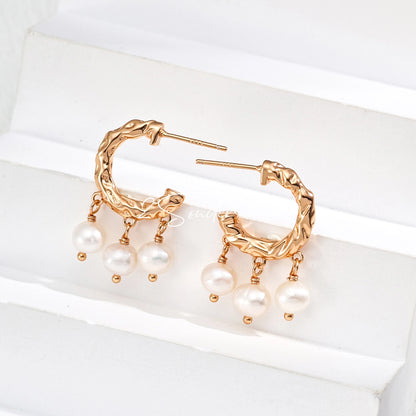 This is a pair of earrings made of sterling silver and natural pearls. The sterling silver is plated with gold, and a crescent-shaped pendant holds three pearls, each approximately 6mm in diameter. The earrings are approximately 2cm in height, a perfect size.