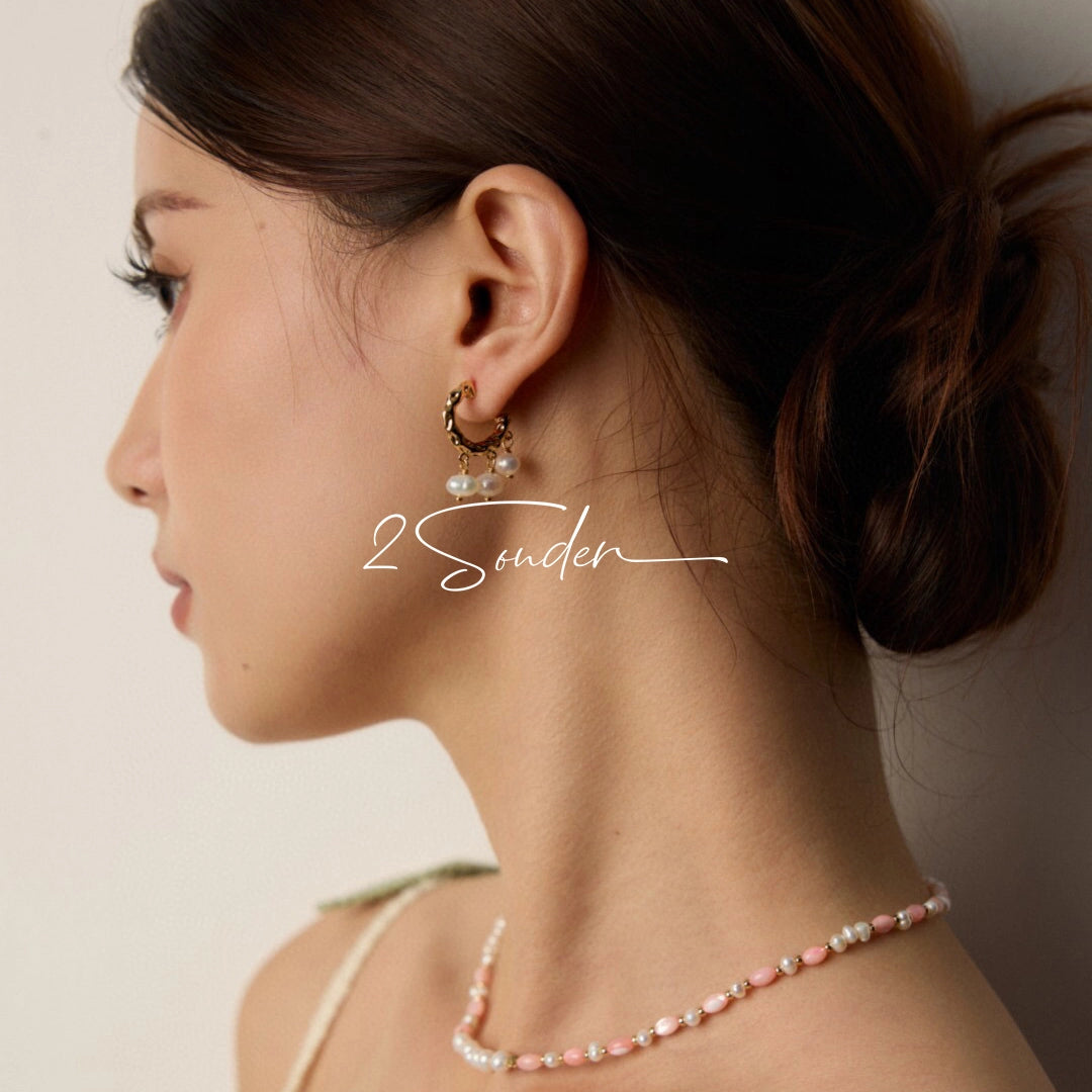 This is a pair of earrings made of sterling silver and natural pearls. The sterling silver is plated with gold, and a crescent-shaped pendant holds three pearls, each approximately 6mm in diameter. The earrings are approximately 2cm in height, a perfect size.