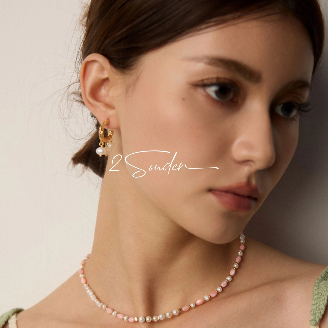 This is a pair of earrings made of sterling silver and natural pearls. The sterling silver is plated with gold, and a crescent-shaped pendant holds three pearls, each approximately 6mm in diameter. The earrings are approximately 2cm in height, a perfect size.