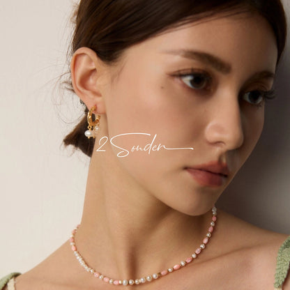 This is a pair of earrings made of sterling silver and natural pearls. The sterling silver is plated with gold, and a crescent-shaped pendant holds three pearls, each approximately 6mm in diameter. The earrings are approximately 2cm in height, a perfect size.