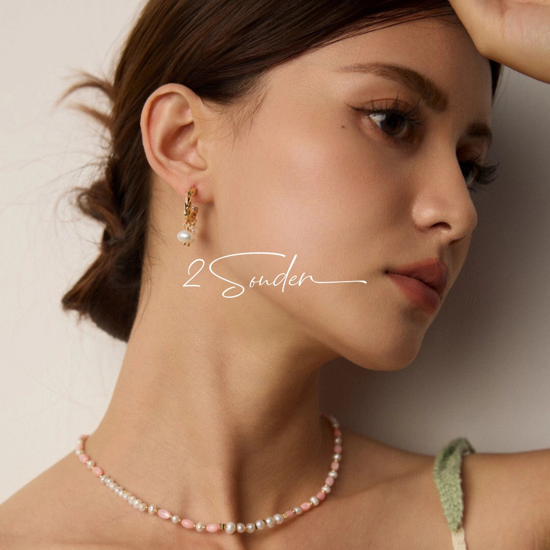 This is a pair of earrings made of sterling silver and natural pearls. The sterling silver is plated with gold, and a crescent-shaped pendant holds three pearls, each approximately 6mm in diameter. The earrings are approximately 2cm in height, a perfect size.