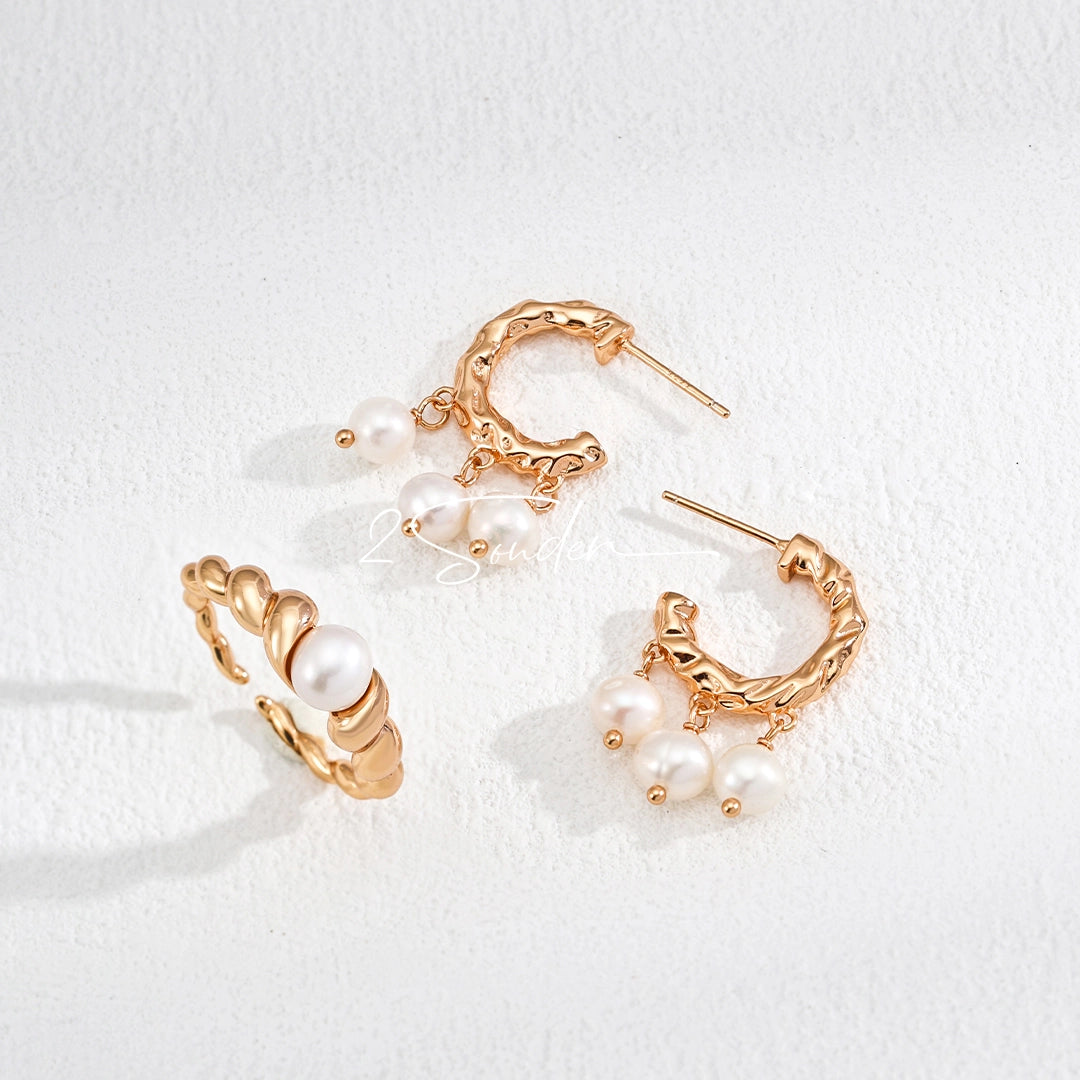 This is a pair of earrings made of sterling silver and natural pearls. The sterling silver is plated with gold, and a crescent-shaped pendant holds three pearls, each approximately 6mm in diameter. The earrings are approximately 2cm in height, a perfect size.