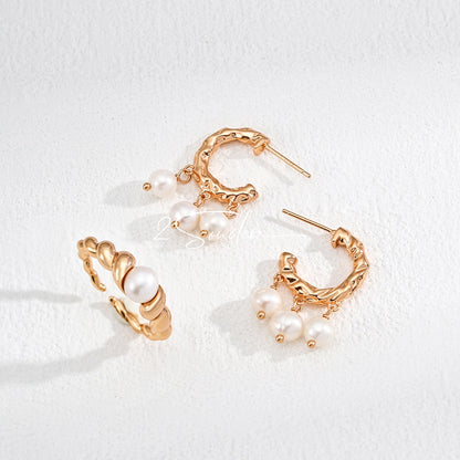 This is a pair of earrings made of sterling silver and natural pearls. The sterling silver is plated with gold, and a crescent-shaped pendant holds three pearls, each approximately 6mm in diameter. The earrings are approximately 2cm in height, a perfect size.