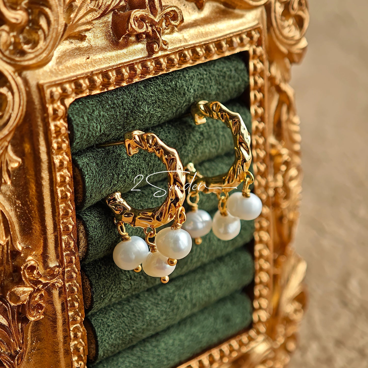 This is a pair of earrings made of sterling silver and natural pearls. The sterling silver is plated with gold, and a crescent-shaped pendant holds three pearls, each approximately 6mm in diameter. The earrings are approximately 2cm in height, a perfect size.
