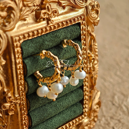 This is a pair of earrings made of sterling silver and natural pearls. The sterling silver is plated with gold, and a crescent-shaped pendant holds three pearls, each approximately 6mm in diameter. The earrings are approximately 2cm in height, a perfect size.