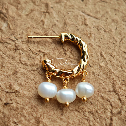 This is a pair of earrings made of sterling silver and natural pearls. The sterling silver is plated with gold, and a crescent-shaped pendant holds three pearls, each approximately 6mm in diameter. The earrings are approximately 2cm in height, a perfect size.