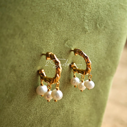 This is a pair of earrings made of sterling silver and natural pearls. The sterling silver is plated with gold, and a crescent-shaped pendant holds three pearls, each approximately 6mm in diameter. The earrings are approximately 2cm in height, a perfect size.