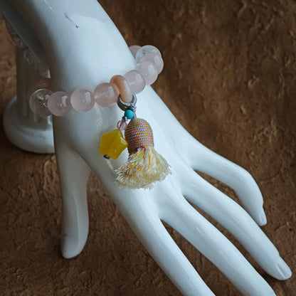 A duet of rose warmth and crystal frost finishes with an amber star charm, agate bead on the move, and a flirtatious tassel.