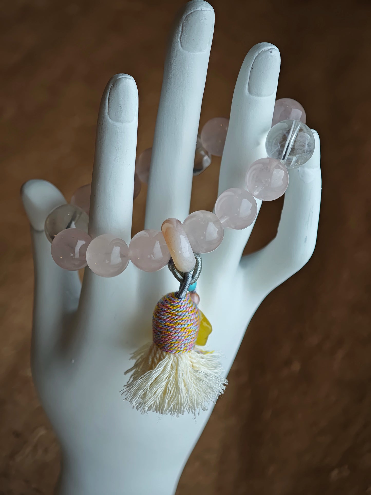 Delicate rose tones mingle with rare azure streaks, then an amber star, adjustable agate bead, and soft tassel complete the story.
