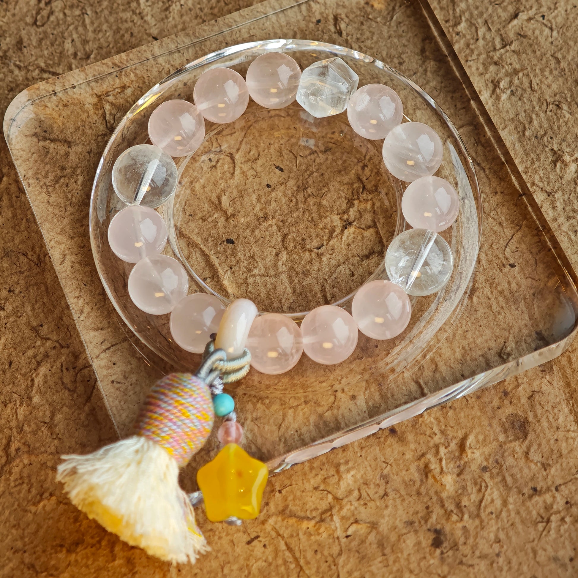 The strand marries peachy quartz and sky-needle crystals, then accents them with an amber star, mobile agate, and elegant sway.