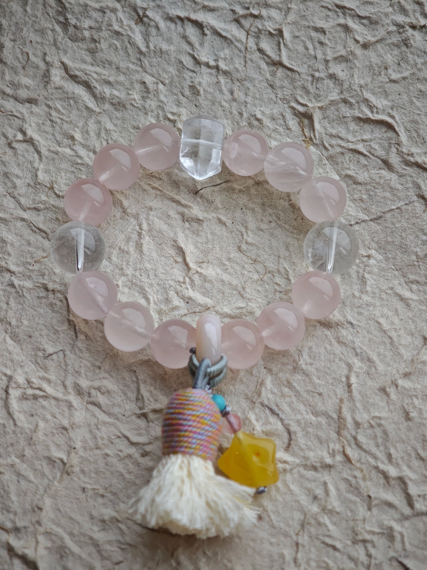 Warm blush stones fuse with cool azure needles, then amber starlight, agate glide, and tassel fringe add bohemian poetry.