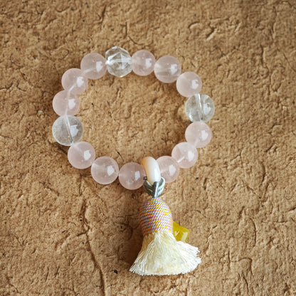 Soft rose quartz and rare blue-needle crystals entwine, while an amber star, sliding agate bead, and silky tassel give the boho design its final flourish.