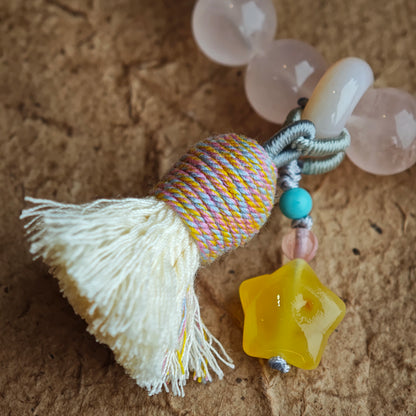 Tender pink gems link to rare blue flashes, while an amber star pendant, gliding agate, and elegant fringe add whimsical polish.