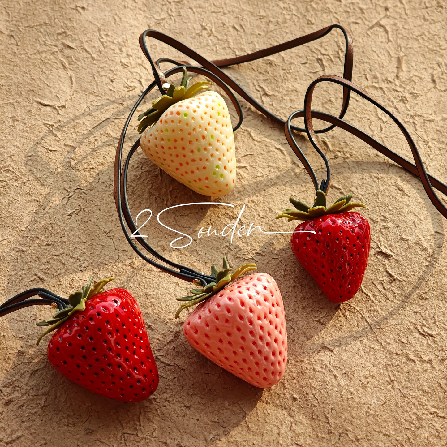 This is a simulated strawberry bag charm. The charm features a strawberry, the same size as a real strawberry, and is made of high-quality resin, giving it a very realistic appearance. It also has a leather cord attached, allowing it to be hung on bags, earphone cases, or used as a keychain. It's versatile and very cute.