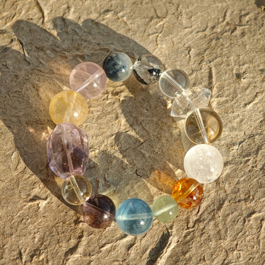 This is a rainbow energy bracelet that consists of Aquamarine, Amethyst, Clear Quartz, White Phantom Quartz, Citrine, Prehnite, Golden Healer, and Herkimer Diamond.