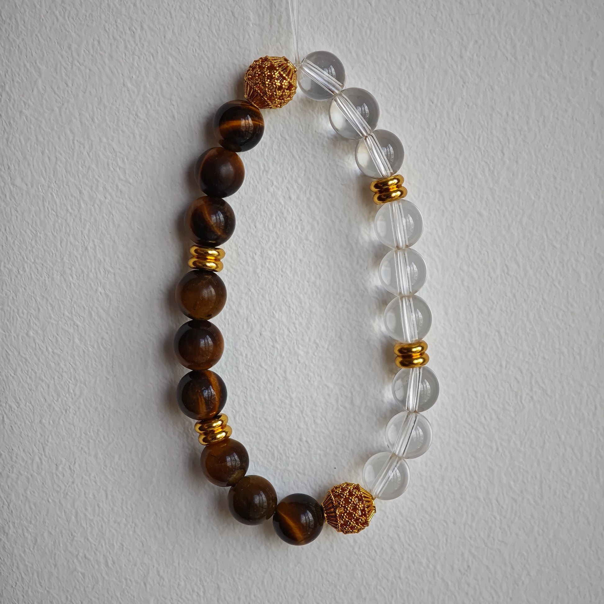 This is a tiger's eye bracelet with clear quartz and gold-plated copper spacer.