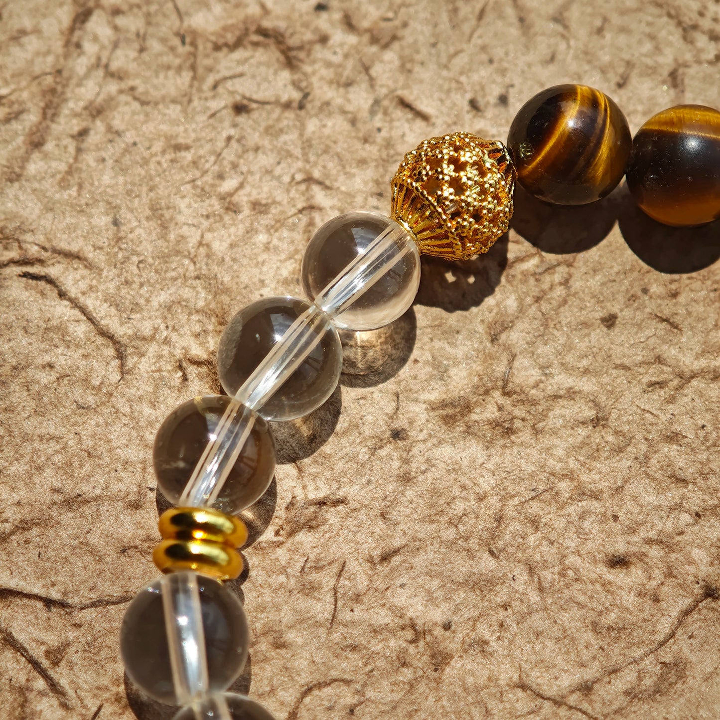 This is a tiger's eye bracelet with clear quartz and gold-plated copper spacer.