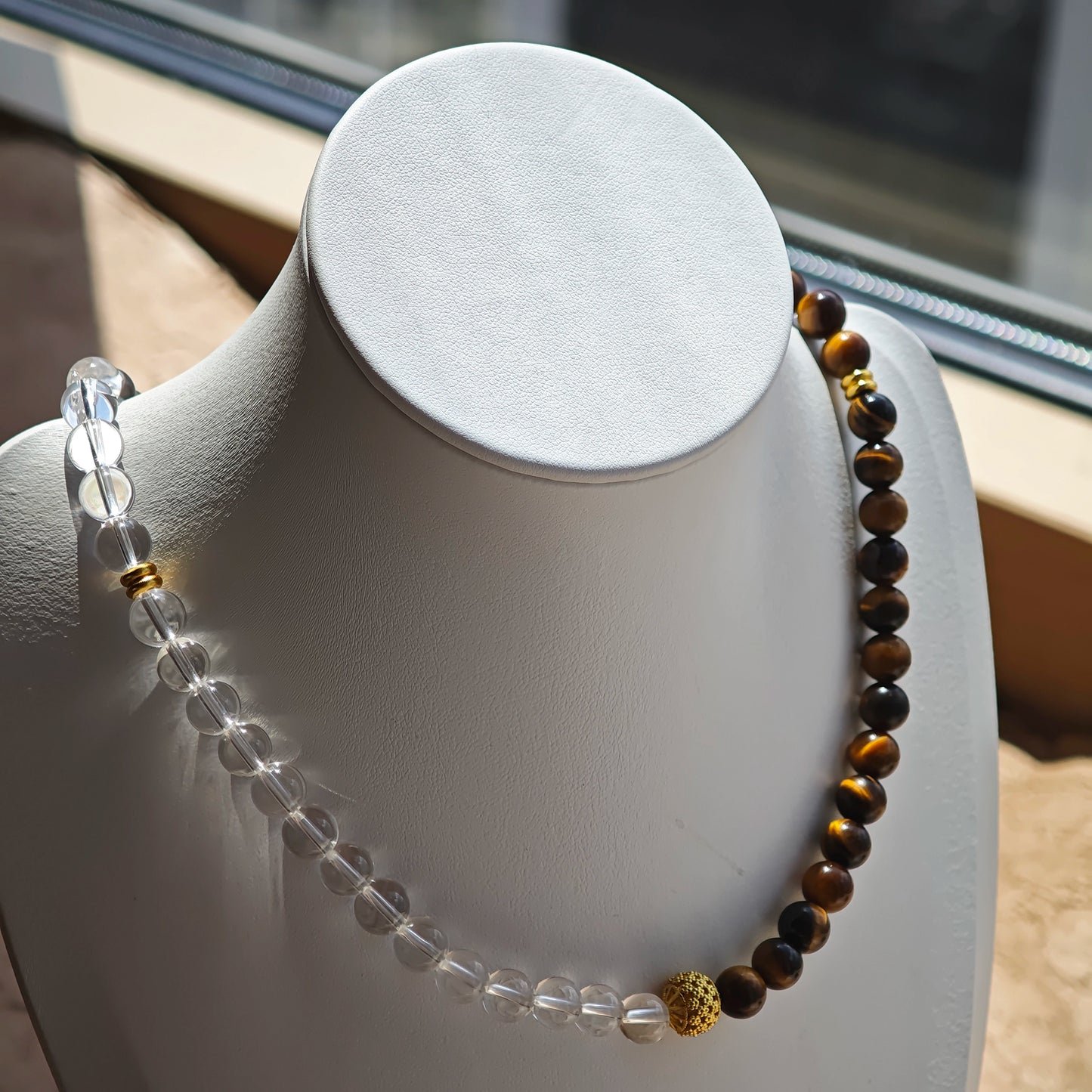 This is a necklace with tiger's eye, clear quartz, gold-plated spacer and elastic cord.