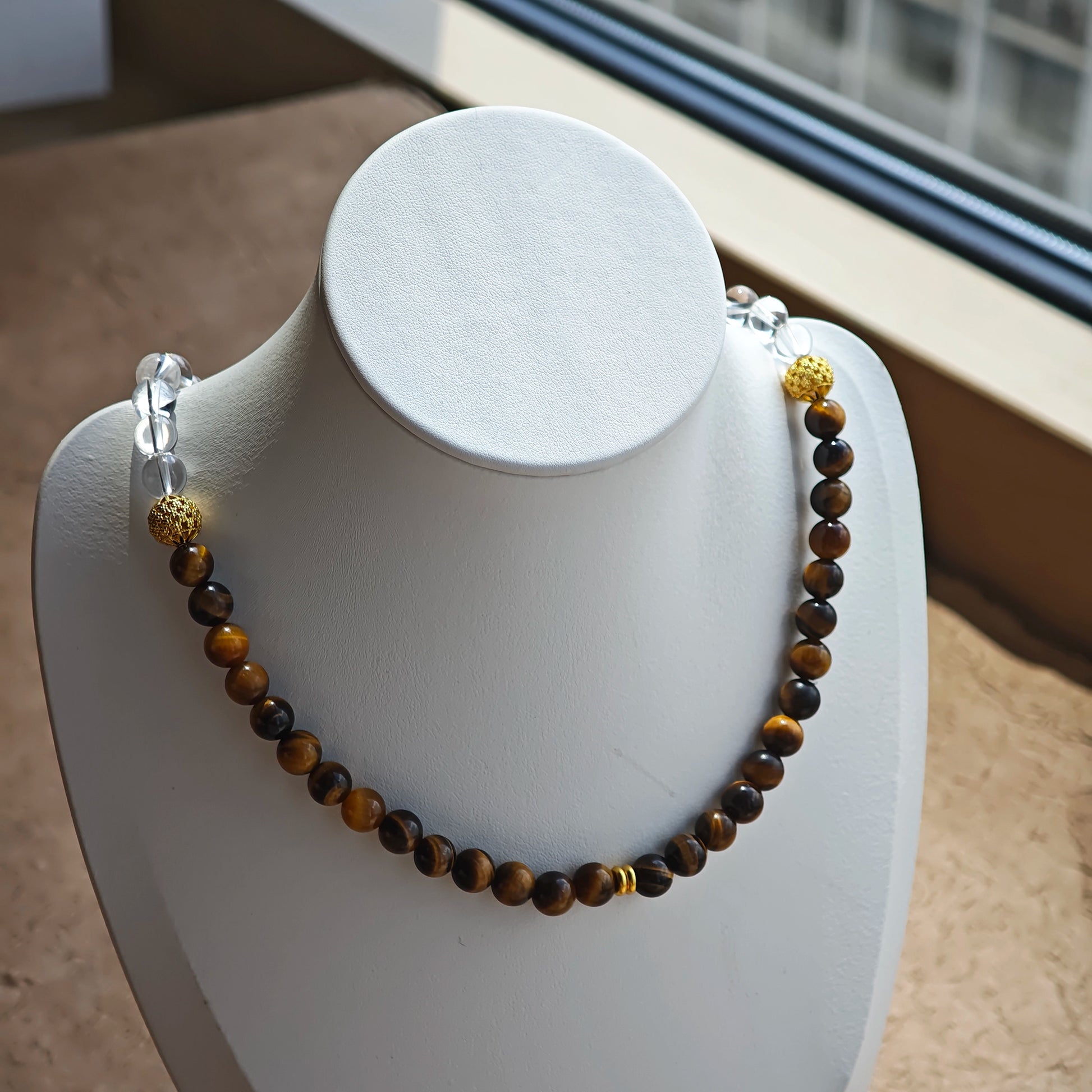 This is a necklace with tiger's eye, clear quartz, gold-plated spacer and elastic cord.
