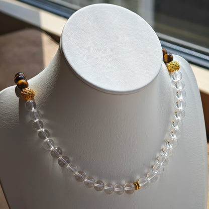This is a necklace with tiger's eye, clear quartz, gold-plated spacer and elastic cord.