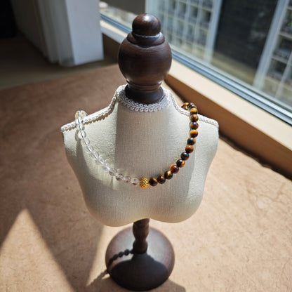 This is a necklace with tiger's eye, clear quartz, gold-plated spacer and elastic cord.