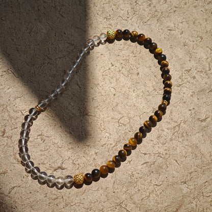 This is a necklace with tiger's eye, clear quartz, gold-plated spacer and elastic cord.
