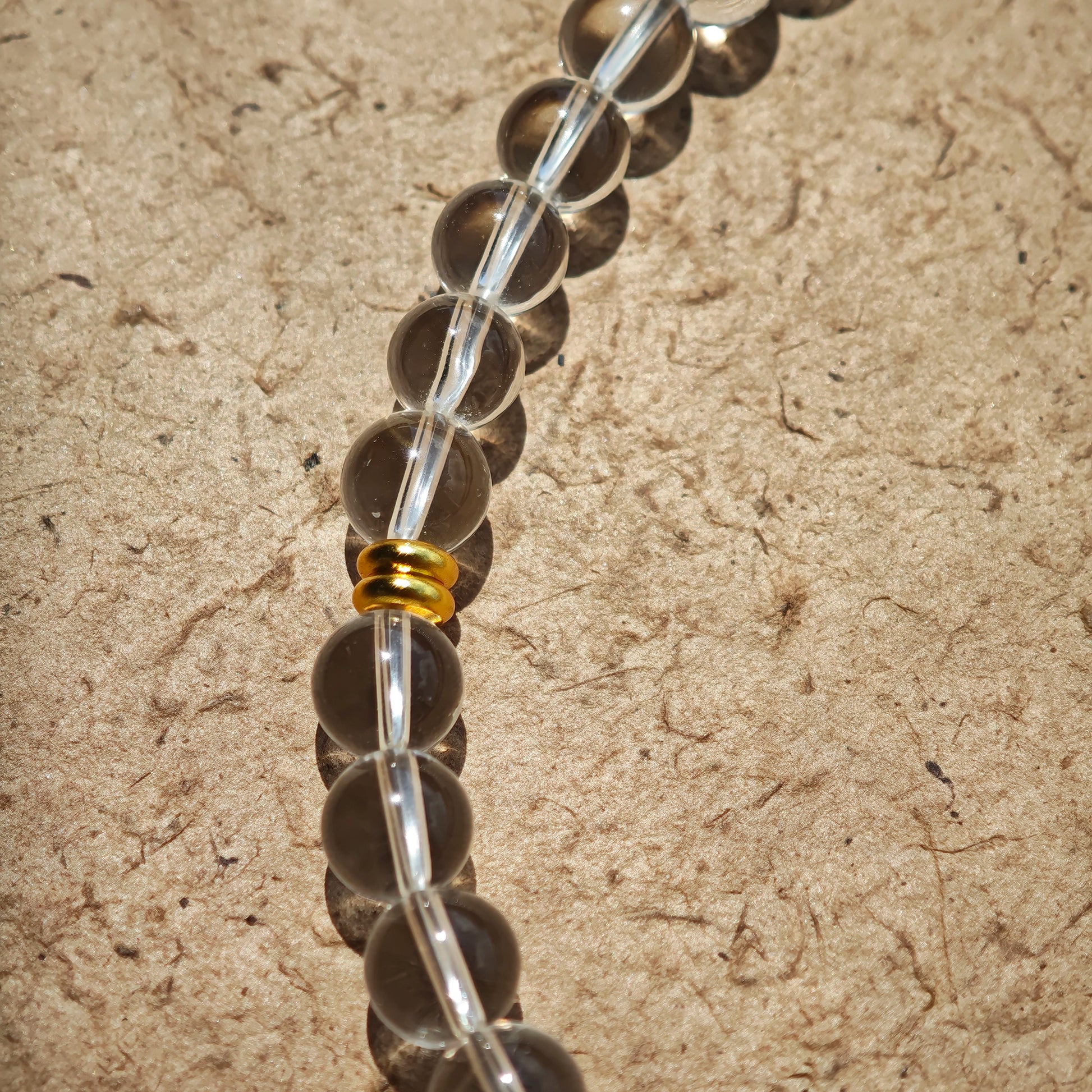 This is a necklace with tiger's eye, clear quartz, gold-plated spacer and elastic cord.