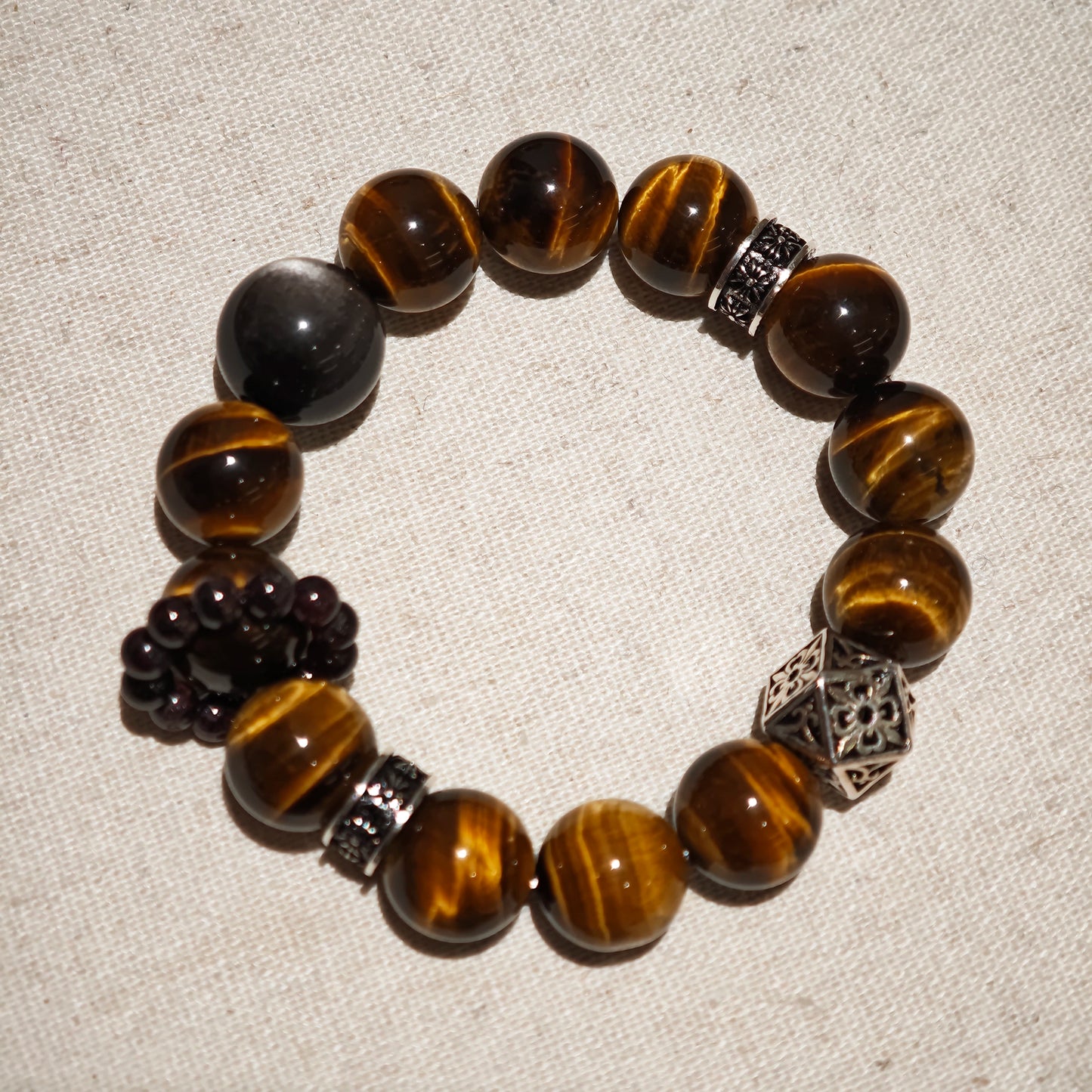 A handmade bracelet with Tiger's Eyes, Silver Sheen Obsidian and Garnet.