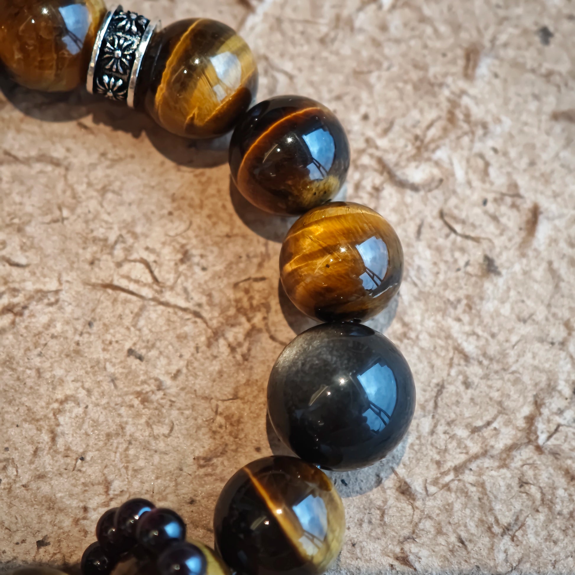 A handmade bracelet with Tiger's Eyes, Silver Sheen Obsidian and Garnet.