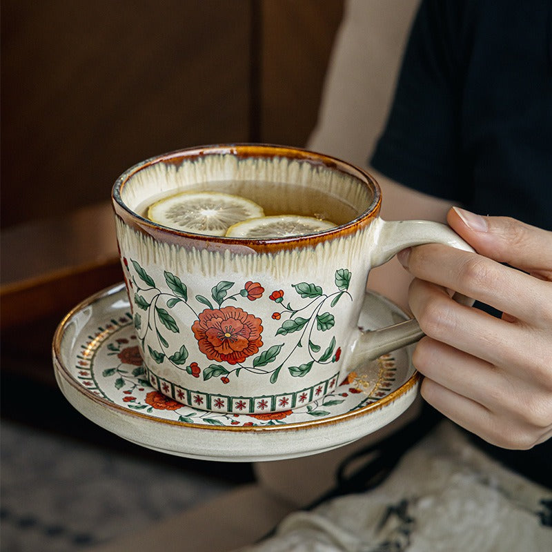 This is a vintage ceramic coffee cup and saucer set with retro floral patterns. The cup capacity is 385ml, and it comes with a saucer. This mid-century inspired ceramic coffee mug set features high-temperature decal floral patterns, kiln-change glaze effects, and elegant gold detailing.