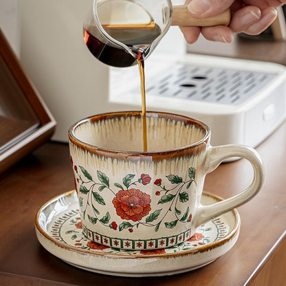 This is a vintage ceramic coffee cup and saucer set with retro floral patterns. The cup capacity is 385ml, and it comes with a saucer. This mid-century inspired ceramic coffee mug set features high-temperature decal floral patterns, kiln-change glaze effects, and elegant gold detailing.