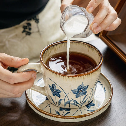 This is a vintage ceramic coffee cup and saucer set with retro floral patterns. The cup capacity is 385ml, and it comes with a saucer. This mid-century inspired ceramic coffee mug set features high-temperature decal floral patterns, kiln-change glaze effects, and elegant gold detailing.