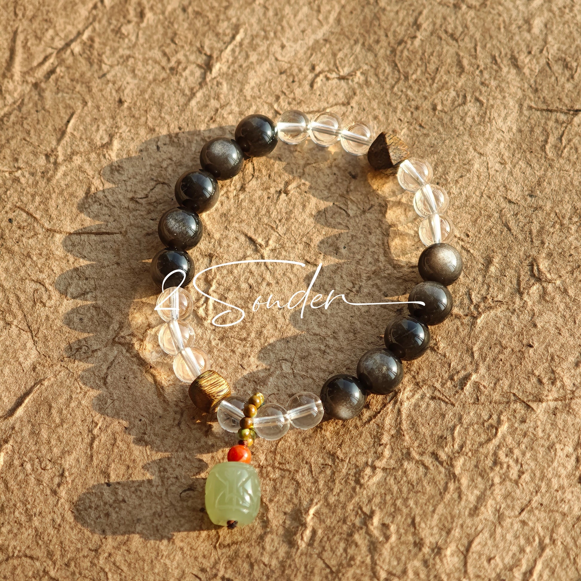This bracelet combines genuine Silver Obsidian (look for the subtle silver sheen under light), high-clarity White Quartz, and Real Agarwood. Unlike synthetic imitations, our Agarwood carries a faint, natural woody scent that deepens over time. Plus, there is an Agate ring in the bracelet, which adds a touch of classical beauty. It feels grounded and real on your skin.
